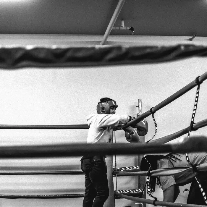 Coach Ren cornering a fighter in the ring, black and white