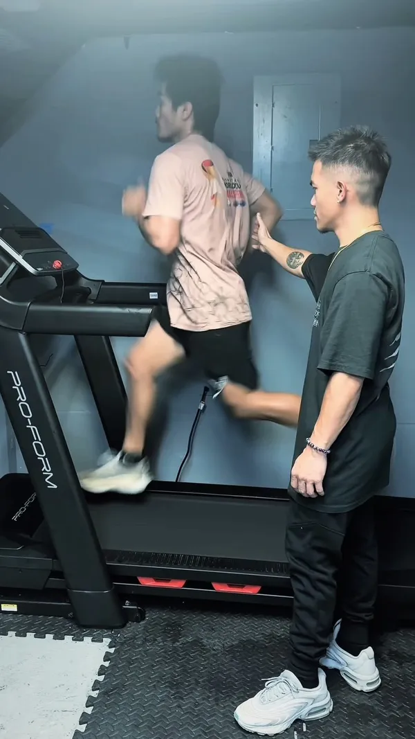 Athlete sprinting on a treadmill while coached